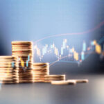 Coin stacks before blue financial graph. Horizontal composition with copy space. Business and finance concept.